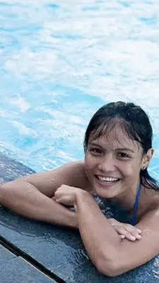 a woman is smiling in a swimming pool at Makati CBD Resort 2 bedroom in Manila