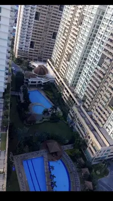 an overhead view of two pools in a city with tall buildings at Makati CBD Resort 2 bedroom in Manila