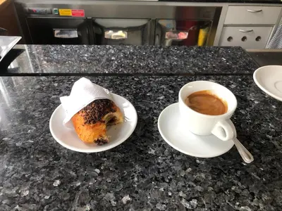 a pastry and a cup of coffee on a counter at Makati CBD Resort 2 bedroom in Manila