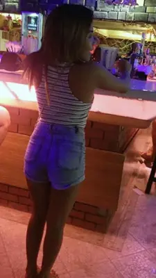 a woman standing in front of a bar at Makati CBD Resort 2 bedroom in Manila