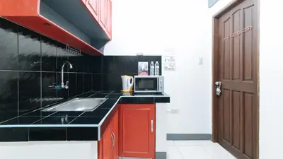 a kitchen with a sink and a microwave at RedDoorz at A&F C5 Pinagsama Taguig in Manila