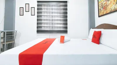 a bedroom with a white bed with red pillows at RedDoorz at A&F C5 Pinagsama Taguig in Manila