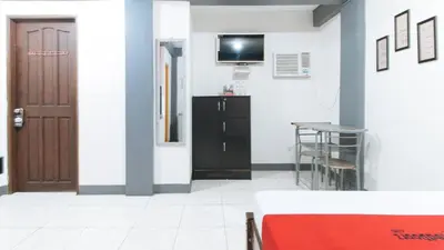 a room with a table and a tv on a wall at RedDoorz at A&F C5 Pinagsama Taguig in Manila