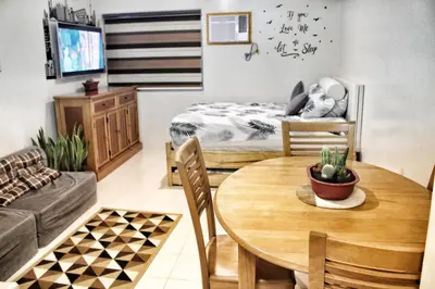 a living room with a table and a bed at CENTROPOLIS 1, Relax & Chill in Manila