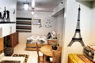 a bedroom with a bed and a table and a tower at CENTROPOLIS 1, Relax & Chill in Manila