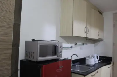 a kitchen with a microwave on top of a refrigerator at Chateau Elysee a14 near Airport Wifi Kitchen in Manila