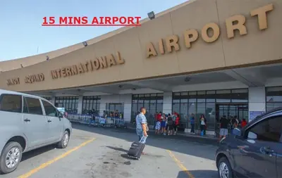 a man with a suitcase in front of a building at Chateau Elysee a14 near Airport Wifi Kitchen in Manila