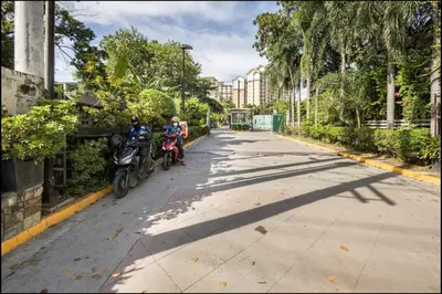 two people on motorcycles parked on a street at A Refreshing Condo Unit Near BGC, Ortigas & Makati with NETFLIX and WiFi in Manila