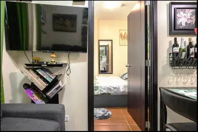 a room with a bedroom with a bed and a television at A Refreshing Condo Unit Near BGC, Ortigas & Makati with NETFLIX and WiFi in Manila