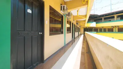 an empty hallway of a building with a black door at RedDoorz near SM City Muntinlupa in Manila