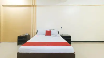a bed in a room with a red pillow on it at RedDoorz near SM City Muntinlupa in Manila