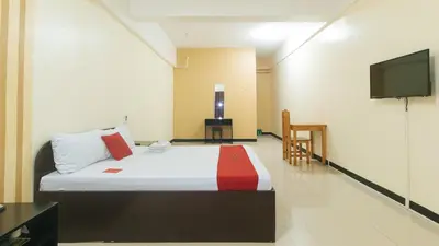 a hotel room with a bed and a flat screen tv at RedDoorz near SM City Muntinlupa in Manila