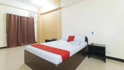 a bedroom with a bed with a red and white blanket at RedDoorz near SM City Muntinlupa in Manila