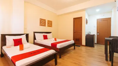 a hotel room with two beds and a table at RedDoorz Plus near Johnson and Johnson Paranaque in Manila
