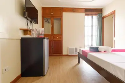 a room with a kitchen with a bed and a refrigerator at RedDoorz Plus near Johnson and Johnson Paranaque in Manila