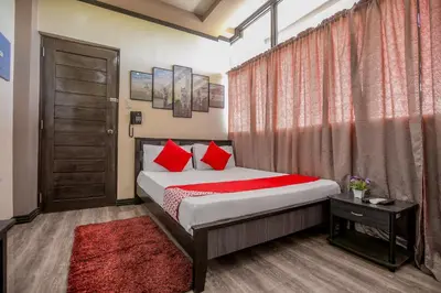 a bedroom with a bed with red pillows at Rjat Guesthouse in Biñan