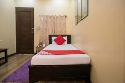 a bedroom with a bed with a red pillow at Rjat Guesthouse in Biñan