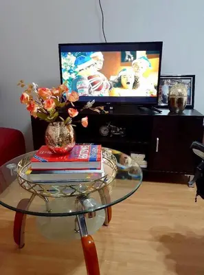 a glass table with books and a vase with flowers on it at Estien’s cozy condo to stay with kitchen in Manila
