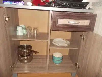 a cupboard with plates and dishes in a kitchen at Estien’s cozy condo to stay with kitchen in Manila