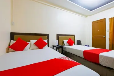 two beds in a room with red and white at OYO 431 Apollo 11 Apartelle in Manila