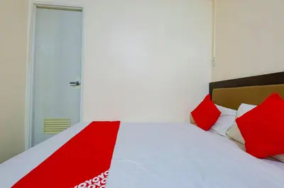 a red and white bed with red pillows on it at OYO 431 Apollo 11 Apartelle in Manila