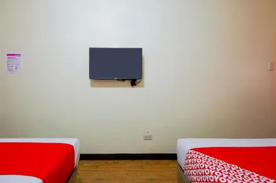 a room with two beds and a tv on the wall at OYO 431 Apollo 11 Apartelle in Manila