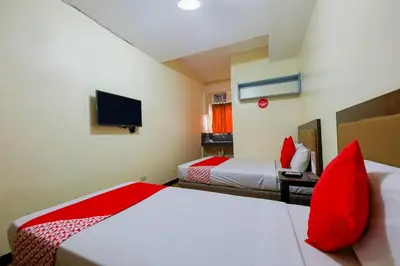 a hotel room with two beds and a flat screen tv at OYO 431 Apollo 11 Apartelle in Manila