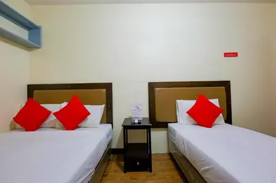 two beds with red pillows in a room at OYO 431 Apollo 11 Apartelle in Manila