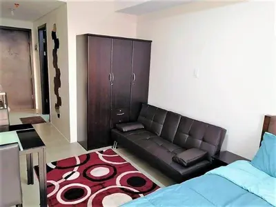 a living room with a couch and a bed at Studio Condominium - Short and Long Term Staycation in Manila