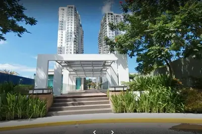 a white building with stairs in front of tall buildings at Studio Condominium - Short and Long Term Staycation in Manila