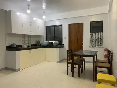 a kitchen with a table and a table and chairs at Matchi in Manila
