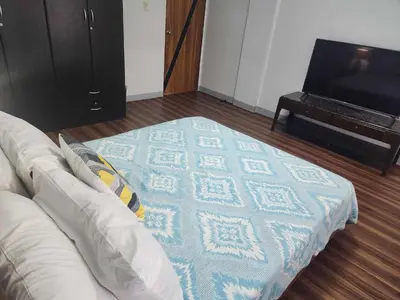 a living room with a couch and a television at Matchi in Manila
