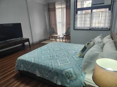 a bedroom with a bed and a flat screen tv at Matchi in Manila
