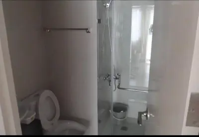 a white bathroom with a toilet and a shower at Favila Condotel unit in Palmtree Villas Newport City walking distance to Airport terminal 3 Accessable to Airport terminal 1 &2 in Manila
