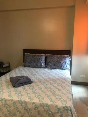 a bedroom with a bed with a shirt on it at Favila Condotel unit in Palmtree Villas Newport City walking distance to Airport terminal 3 Accessable to Airport terminal 1 &2 in Manila