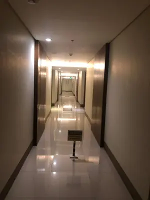 a hallway in a building with a sign on the floor at Favila Condotel unit in Palmtree Villas Newport City walking distance to Airport terminal 3 Accessable to Airport terminal 1 &2 in Manila