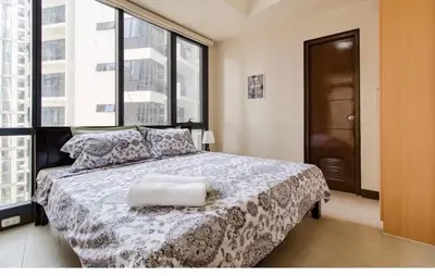 a bedroom with a bed with a large window at Madisons Crib at The Florence in Manila