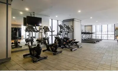 a gym with several treadmills and cardio machines at Madisons Crib at The Florence in Manila