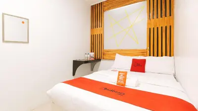 a bedroom with a bed with a red and white blanket at RedDoorz near Quiapo Church Manila in Manila