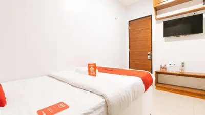 a small room with two beds and a television at RedDoorz near Quiapo Church Manila in Manila