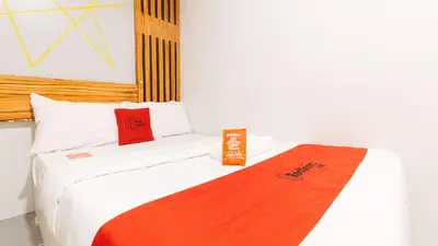 a room with a bed with a red blanket on it at RedDoorz near Quiapo Church Manila in Manila