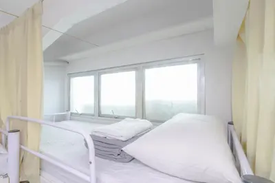 a bedroom with two beds and a large window at ARK Hostel City Center Manila in Manila