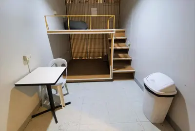 a room with a toilet and a table and stairs at ARK Hostel City Center Manila in Manila