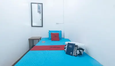 a small room with a bed with a book on it at RedDoorz near OWWA Pasay in Manila