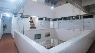 a large room with white walls and a staircase at RedDoorz near OWWA Pasay in Manila