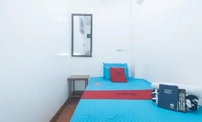 a small room with a bed with a phone on it at RedDoorz near OWWA Pasay in Manila