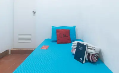 a bedroom with a blue bed with a book on it at RedDoorz near OWWA Pasay in Manila