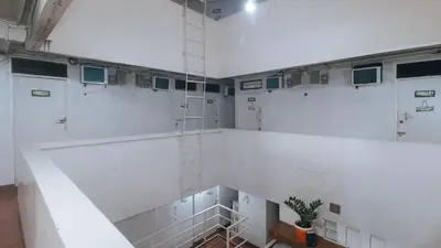 a room with white walls and a staircase with a plant at RedDoorz near OWWA Pasay in Manila