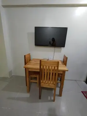 a wooden table with two chairs and a television on a wall at Mhavic family room ,group friend good for 6 guest in Manila