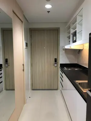 a kitchen with a wooden door in a room at Sithonia Suite, Shore Residences Tower C near MOA in Manila